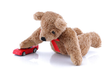 Teddy bear playing with his toy car