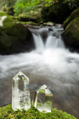 沢をバックに苔の上の水晶の結晶