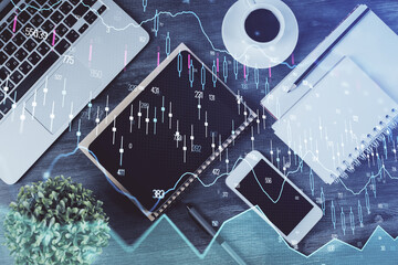 Double exposure of forex chart hologram over desktop with phone. Top view. Mobile trade platform concept.