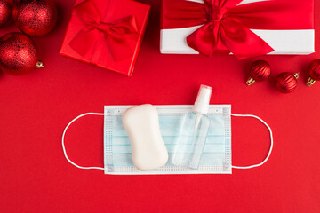 Merry Christmas concept. Top above overhead close up flat lay photo of newyear packages and medicine hygienic filter cover sanitizing gel and white bar of soap isolated bright red color background