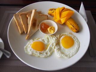 Fototapeta premium Breakfast set, Sunny-Side Up Fried Eggs, Sandwich, Mango, Banana, and Jam, Nalusuan Island, Cebu, Philippines