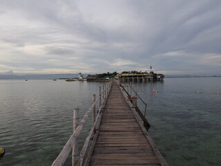 Fototapeta na wymiar A long wooden bridge leading to the island, Marine Sanctuary, Nalusuan Island, Cebu, Philippines