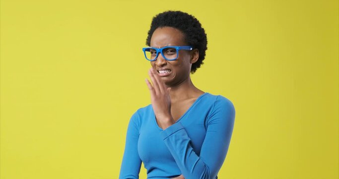 African american woman with disgusted expression repulsing something over yellow background
