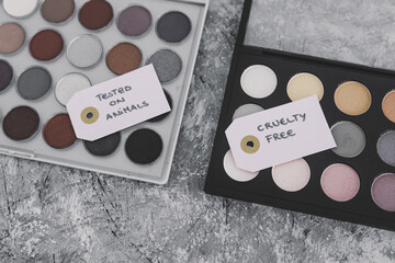 Obraz na płótnie Canvas cruelty free vs animal tested cosmetics eyeshadow palettes with text on labels