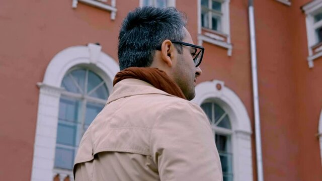 The handsome man of Oriental appearance, a poet and artist with glasses. Intellectual. The camera rotation around the guy 360 degrees. Slow motion