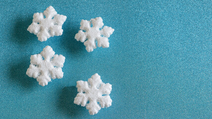 Winter snowflakes on the aqua blue Christmas background. Banner photo, top view.