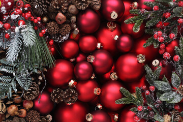 merry christmas background, top view of stack of colorful glass balls in red with mistletoe and pine cones, useful as a greeting gift card template