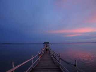 A woman stares at the beautiful reddish sky after sunset, Marine Sanctuary, Nalusuan Island, Cebu,...