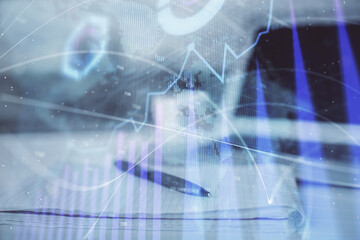 Fototapeta na wymiar Double exposure of financial graph drawings and desk with open notebook background. Concept of forex market