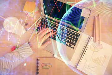 Double exposure of man's hands typing over computer keyboard and forex graph hologram drawing. Top view. Financial markets concept.