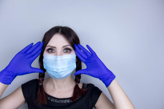 Woman wearing protection face mask against coronavirus. Woman in a mask looking shocked or worried with hand up. Medical mask, medical gloves, Close up shot, Select focus, Prevention from covid19