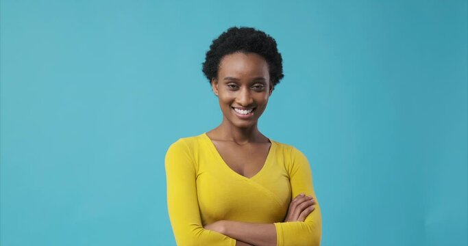 Happy african american woman with arms crossed over blue background