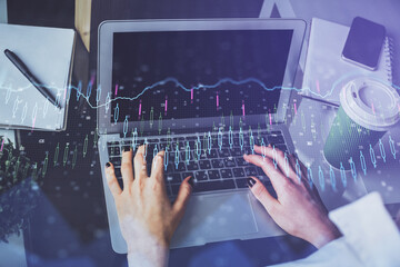 Double exposure of woman hands typing on computer and forex chart hologram drawing. Stock market invest concept.