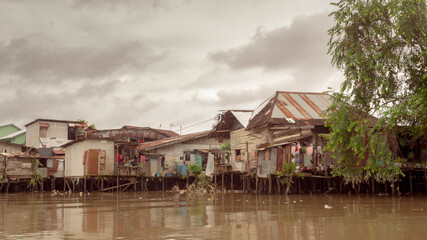 Obraz premium Wooden house on Karang Mumus Riverbank. Slum area on Karang Mumus river, Samarinda, Indonesia