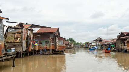 Fototapeta na wymiar Wooden house on Karang Mumus Riverbank. Slum area on Karang Mumus river, Samarinda, Indonesia