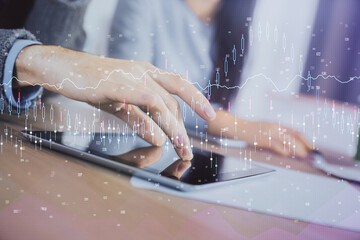 Double exposure of forex graph drawing and man and woman working together holding and using a mobile device. Trade concept.