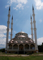 New mosque with white minarets in sunlight.