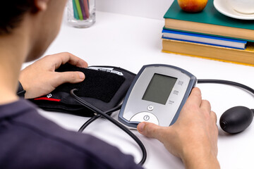 caucasian male person self check blood pressure using electronic tonometer. hypertension problem concept