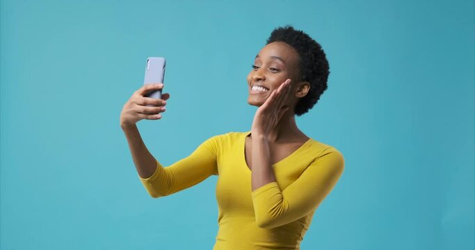 Happy african american woman taking selfie and photo messaging using mobile phone