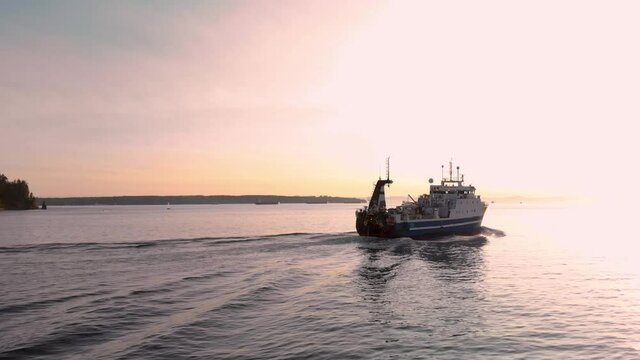 A large fishing vessel leaving Vancouver harbor at sunset. 4K 24FPS.