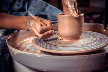 Craftsman master sculptor works with clay on a Potter's wheel and at the table with the tools....