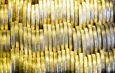 many round metal coins of silver color illuminated with Golden color