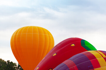 Obraz premium three balloons of orange red and multicolored flowers against the cloudy sky