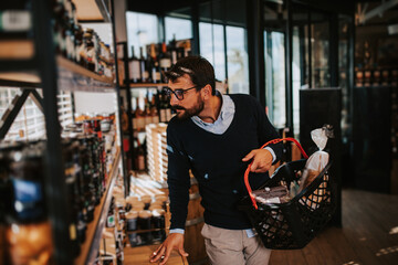 Handsome middle age man buying some healthy food and drink in modern supermarket or grocery store....