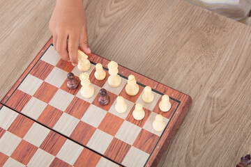 Obraz na płótnie Canvas Close-up child's hand is playing chess