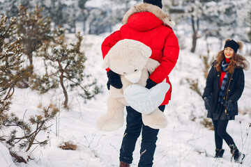 Elegant couple in a winter park. Man in a black jacket. Lady with long hair