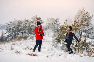 Elegant couple in a winter park. Man in a black jacket. Lady with long hair