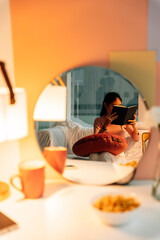 Woman reading a book before sleep in bedroom.