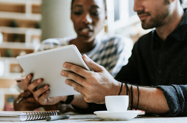 Colleagues discussing their work on a tablet