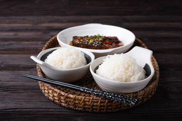 Bowl of boiled rice served on wooden table,