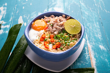 Instant noodles with minced pork and egg in bowl.