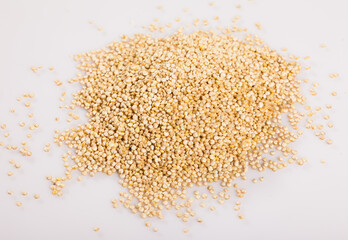 Heap of raw seeds of quinoa on white surface. Healthy nutrition..