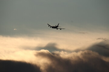 A plane coming in to land before sunset.