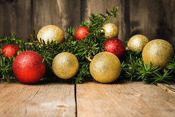 Christmas background with green branches and christmas balls on the rustic wooden background....