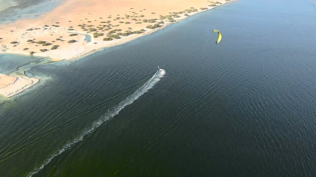 drone shoot of a kite surfer surfing on the creek