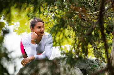 Fototapeta na wymiar young woman 20-25 years old in sportswear in a park, looking at camera