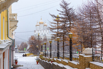 Beautiful view of the snow-covered city street and the Cathedral during a snowfall. Travel to Siberia and the Russian Far East. Sights of the city of Magadan. Magadan Region, Russia. Mid October.