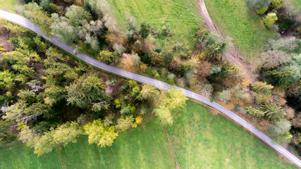 Top view of road in forest and green fields