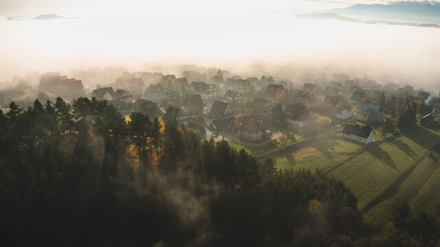 Mountain village in a early moorning with fog and autumn leaves