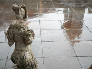 Reflection of the wet area of temple Wat Arun in Thailand With the foreground is the back of a cement sculpture
