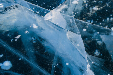 Winter Baikal, covered with a thick layer of transparent ice with cracks and white frozen methane bubbles. Copy space.