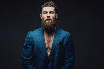 Obraz premium Bearded and mature businessman posing in blue suite with stylish haircut and serious face in dark background.