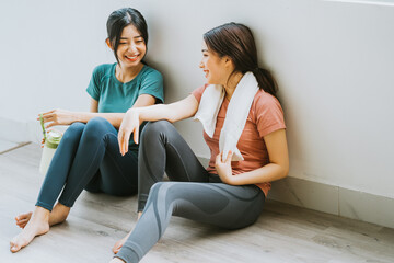 Two Asian women taking a break from yoga session
