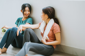 Two Asian women taking a break from yoga session
