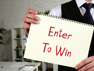 Financial concept meaning Enter To Win with sign on the piece of paper.