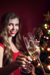 portrait of nice woman in red dress with champagne in christmas environment